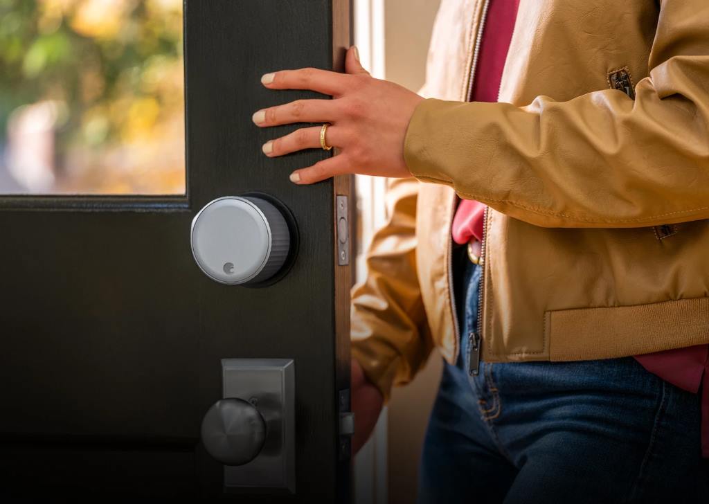 August smart lock installed on door with app screen showing geofence map